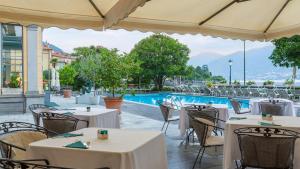 a restaurant with tables and chairs and a swimming pool at Grand Hotel Menaggio in Menaggio
