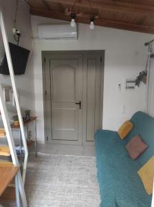 a room with a door and a bed and a ladder at Sweet little studio in Leonidio