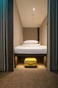 a yellow suitcase sitting on the floor next to a bed at OstelloMaree 오스텔로마레 Tax Benefit in Seoul