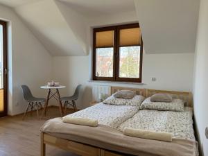a bedroom with a bed and a table with chairs at Noclegi Widokowa Przystań in Krajno Pierwsze