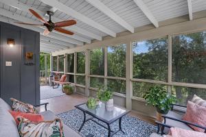 a living room with a ceiling fan and windows at Lily Pad in Wimberley +26 photos