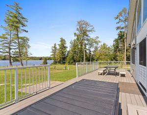 a deck with a table and a bench on a house at Swan Shores-Expansive Lakefront Home with Private Dock in Grand Junction