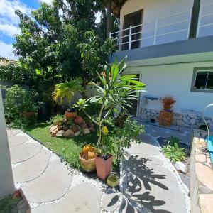 a garden with plants and a house at Charmosa suíte de Tucuns. in Búzios