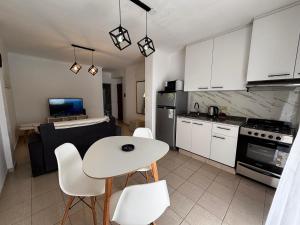 a kitchen with a white table and white chairs at Casa serena apart in Paraná