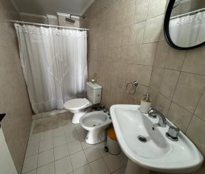 a bathroom with a sink and a toilet and a mirror at Casa serena apart in Paraná