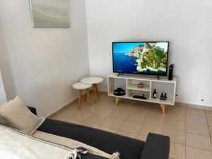 a living room with a flat screen tv on a cabinet at Casa serena apart in Paraná