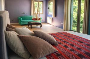 a bedroom with a bed and a green couch at Suite Republica del Tango Gonnet in Joaquín Gorina