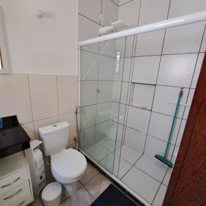 a bathroom with a toilet and a glass shower at Charmosa suíte de Tucuns. in Búzios +14 photos