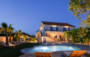 a house with a swimming pool in front of a building at Magna in Dobropoljana