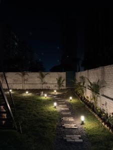 a pathway with lights in the grass at night at Palm Stone Villa in Lucknow