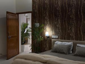 a bedroom with a bed with a tree wall at Palm Stone Villa in Lucknow +41 photos
