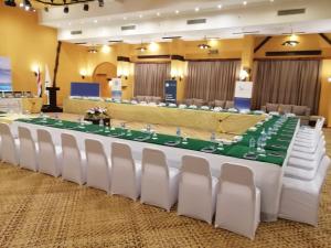 a long table with white chairs in a room at Swisstouch Oriental Resort in Coraya Bay +166 photos