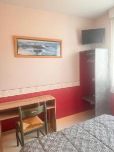 a bedroom with a desk and a tv on the wall at Hostellerie de la juhel in Villaines-la-Juhel
