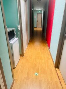a long hallway with a television and a wooden floor at Hostellerie de la juhel in Villaines-la-Juhel