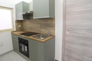 a small kitchen with a sink and a stove at B&B RoseMary in La Maddalena