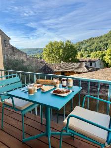 a blue table and chairs on a deck with food on it at La Fontaine du Soleil in Salernes