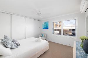 a white bedroom with a bed and a window at Sundeck Shoal Bay Ground floor with views and pool access in Shoal Bay +22 photos