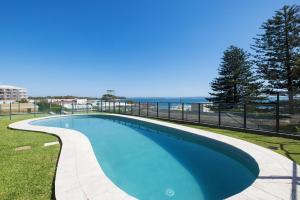 a swimming pool with the ocean in the background at Sundeck Shoal Bay Ground floor with views and pool access in Shoal Bay