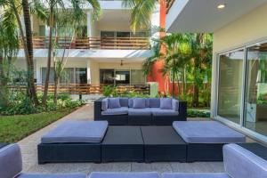 a patio with a couch and tables in front of a building at Grand Blue Playa in Playa del Carmen