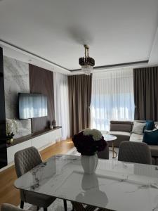 a living room with a table and a couch at Moderan 80m2 apartman - 2 kupatila - terasa - blizu centra i plaze in Bar