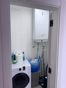 a kitchen with a washing machine and a cabinet at Moderan 80m2 apartman - 2 kupatila - terasa - blizu centra i plaze in Bar +15 photos