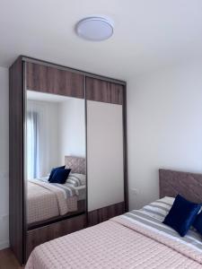 a bedroom with two beds and a large mirror at Moderan 80m2 apartman - 2 kupatila - terasa - blizu centra i plaze in Bar