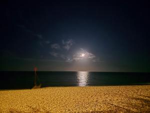 a beach with the sun shining over the ocean at Private Double Room near Bognor Beach! in Bognor Regis