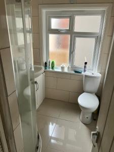 a bathroom with a shower and a toilet and a window at Private Double Room near Bognor Beach! in Bognor Regis