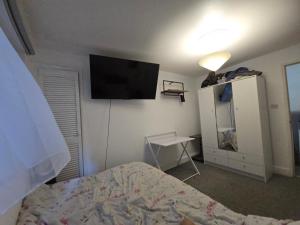 a bedroom with a bed and a television on the wall at Private Double Room near Bognor Beach! in Bognor Regis