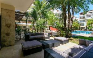 a patio with couches and a pool in a building at Grand Blue Playa in Playa del Carmen
