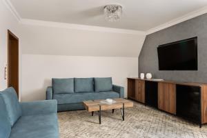 a living room with a couch and a tv at Hotel Sylwia in Sośnicowice