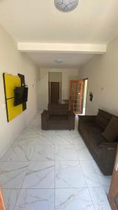 a living room with a couch and a table at Casa Aconchego in Japaratinga