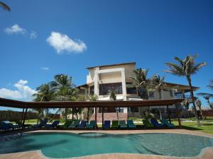 a house with a swimming pool in front of a house at Beachfront Studio with Pool Caponga in Cascavel