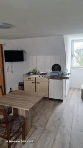 a kitchen with a wooden table in a room at My Pension City Stadtbergen Augsburg in Stadtbergen