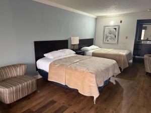 a hotel room with two beds and a couch at Soho inn & suites in Perry