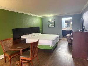 a bedroom with a bed and a table and chairs at Soho inn & suites in Perry +2 photos
