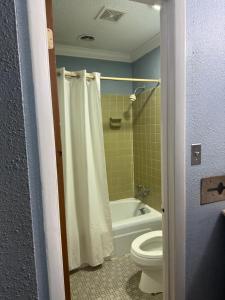 a bathroom with a toilet and a tub and a shower at Soho inn & suites in Perry