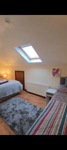 a bedroom with a bed and a skylight at Antrim Heights B&B Panoramic Views & Free Parking in Antrim