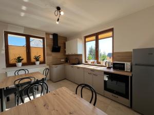a kitchen with a table and some chairs in it at Noclegi Widokowa Przystań in Krajno Pierwsze