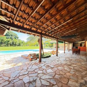 an outdoor patio with a wooden pergola at Chacara Italia in Uberaba