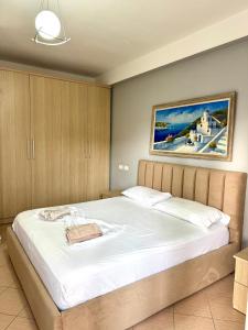 a bedroom with a large bed with a painting on the wall at Beach Apartments Durres in Durrës