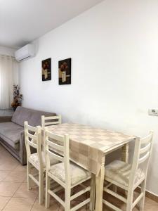 a dining room with a table and chairs and a couch at Beach Apartments Durres in Durrës