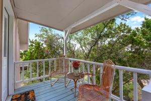 a porch with two chairs and a table with a vase of flowers at Lomax Lookout in Wimberley