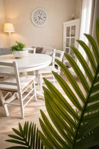 a dining room with a table and chairs and a clock at Le Petit Nid de Beauval in Saint-Aignan