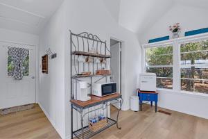 a room with a kitchen with a microwave and a shelf at Lomax Lookout in Wimberley +38 photos