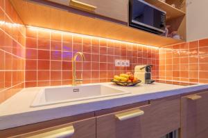 a kitchen with a sink and a bowl of fruit at Marrakech Cinéma Jacuzzi - Suite romantique in Feyzin +27 photos
