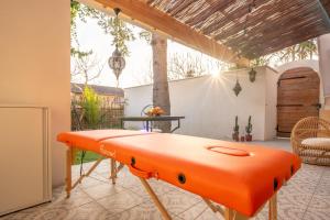 an orange bench sitting on a patio at Marrakech Cinéma Jacuzzi - Suite romantique in Feyzin