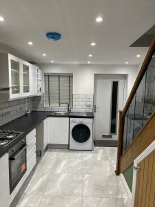 a kitchen with a washer and dryer in it at The Ivy in Marston Green