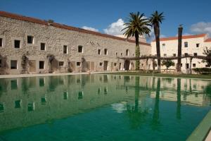 a large pool of water in front of a building at Tavira Convent, 2-bedroom, condo, pool in Tavira