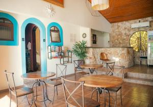 a restaurant with tables and chairs in a room at Pousada Flor de Penedo in Penedo